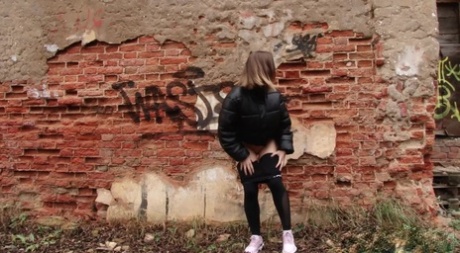 Nice girl Lera pulls down black leggings to pee behind a dilapidated building 29452924